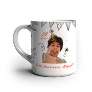 Caneca personalizada com tema de aniversário infantil, com foto de uma criança usando chapéu de festa, texto “10 anos” e “Feliz Aniversário, Miguel!” com desenhos de bandeirinhas e confetes.